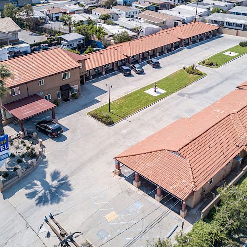 The image shows an aerial view of a motel with parking spaces, a sign reading 